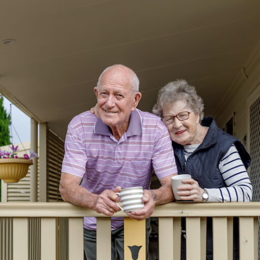 A senior man and woman enjoy a morning on their porch with a mug of coffee, demonstrating the importance of maintaining your independence and quality of life.