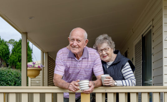 A senior man and woman enjoy a morning on their porch with a mug of coffee, demonstrating the importance of maintaining your independence and quality of life.