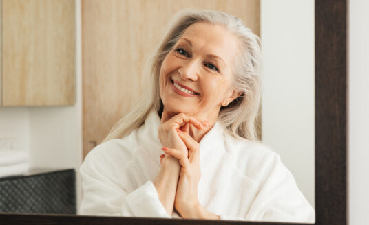 Senior woman looking in mirror | How to age with grace