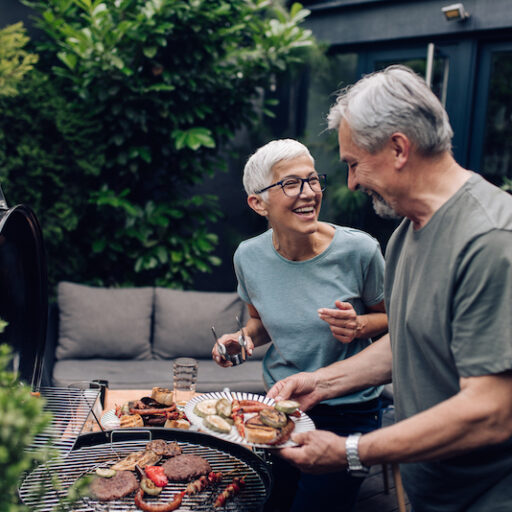 Older couple grilling meat and enjoying fun activities for seniors