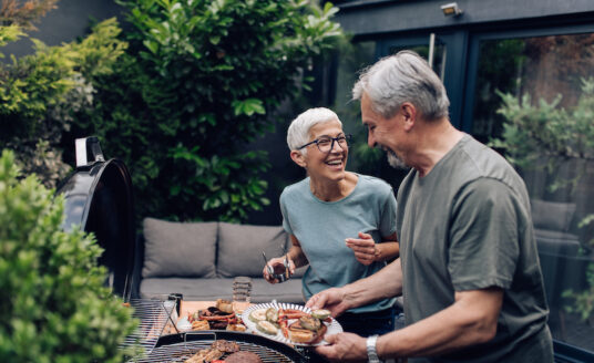 Older couple grilling meat and enjoying fun activities for seniors