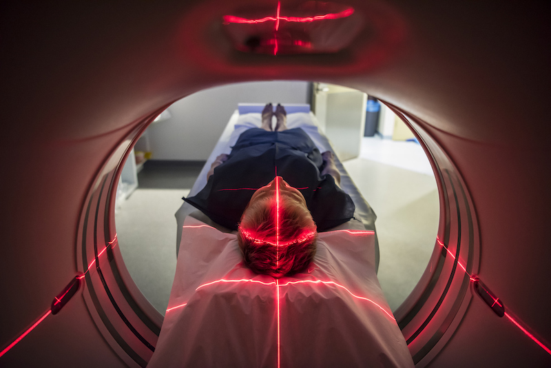 Patient lying inside a medical scanner in hospital getting a memory screening
