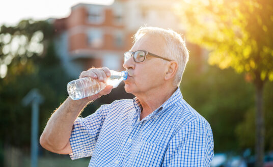 senior man drinking water and avoiding the dangers of humidity