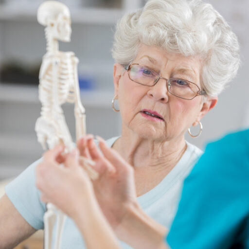 Senior woman discusses aging bones with physical therapist