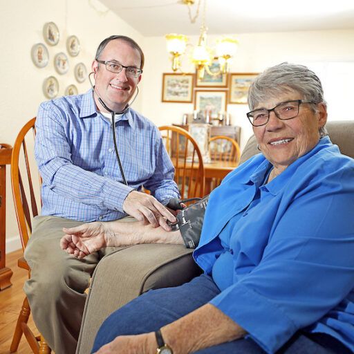 doctor taking house calls and monitoring older woman