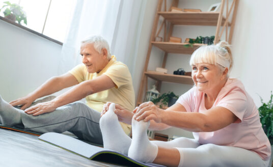 Senior couple doing yoga exercises for arthritis