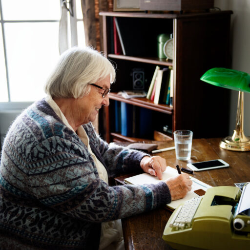 Woman writing letter demonstrating pen pals for seniors