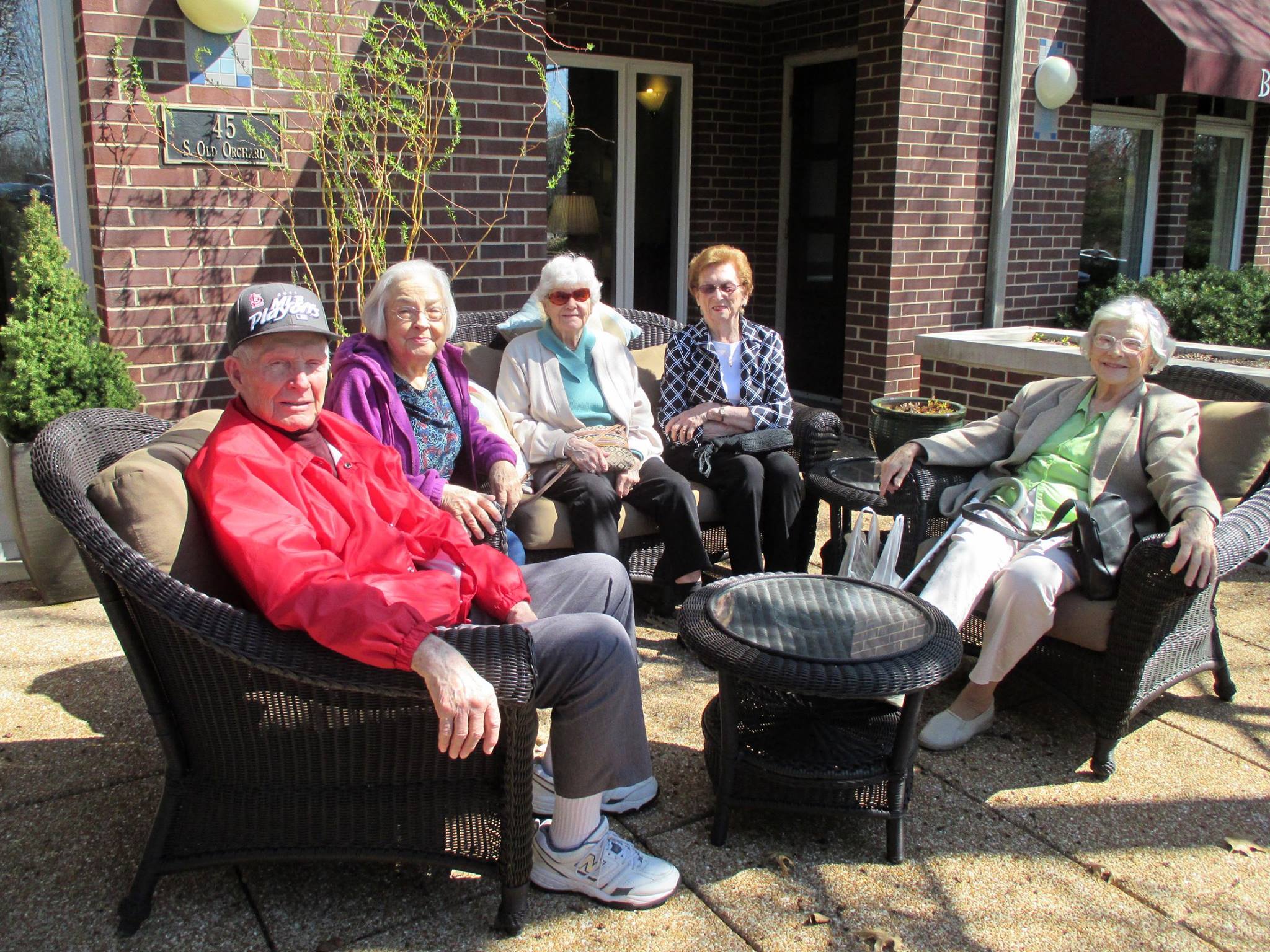 Men and women sitting on a patio in teh sun