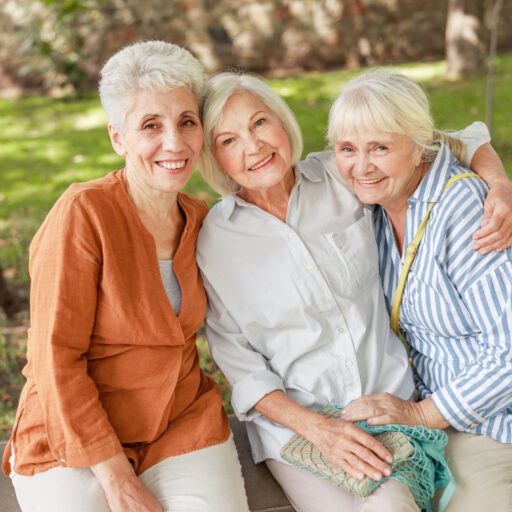 Three friends sitting outside on a wall