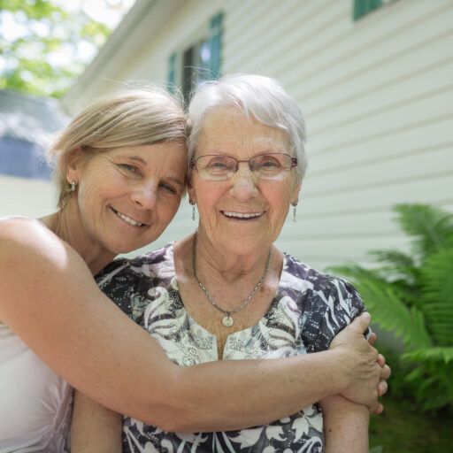 Senior and adult child hugging | Seeking out memory care and a dementia care plan