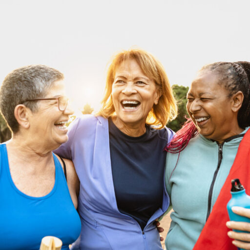 Happy multiracial senior women having fun after workout exercises in the park