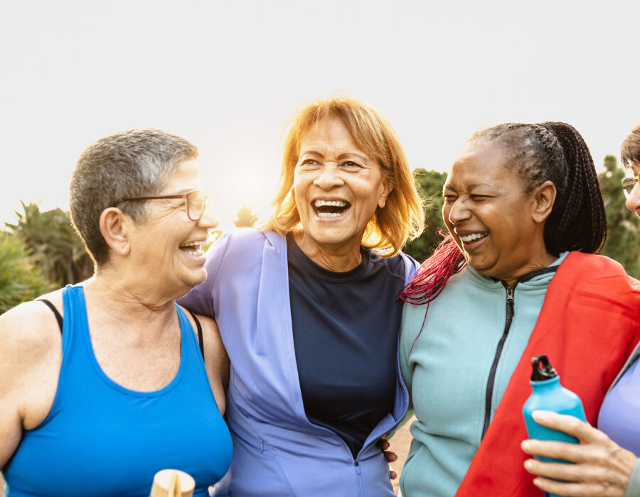 Happy multiracial senior women having fun after workout exercises in the park