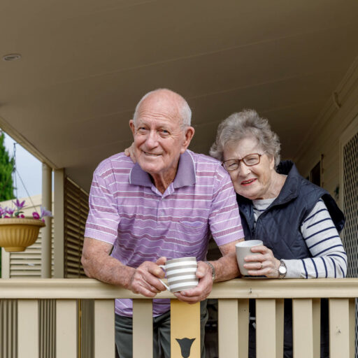 Elderly couple drinking coffee at their house's front porch