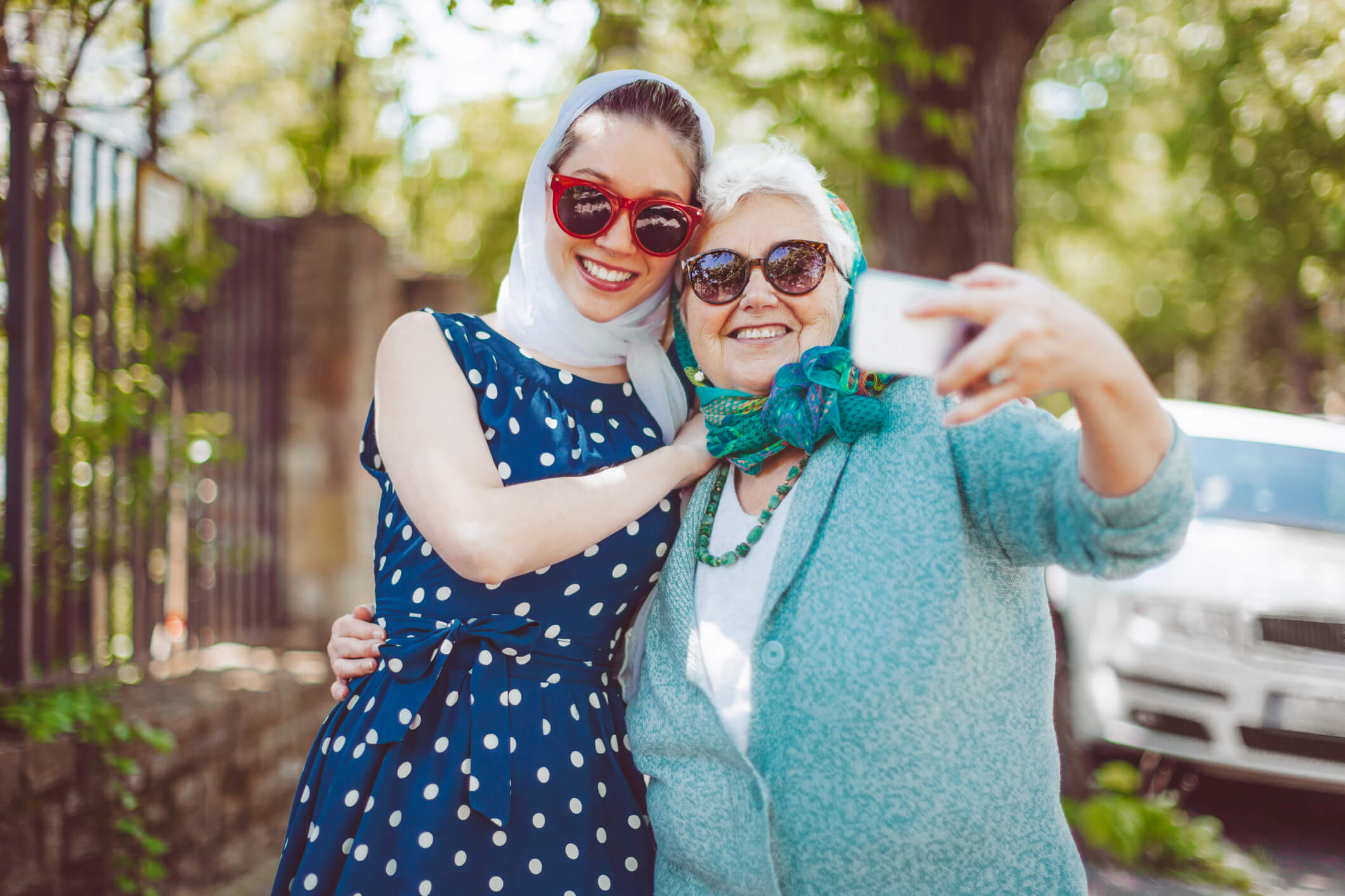 Senior woman and grand daughter smiling for the camera while taking a selfie