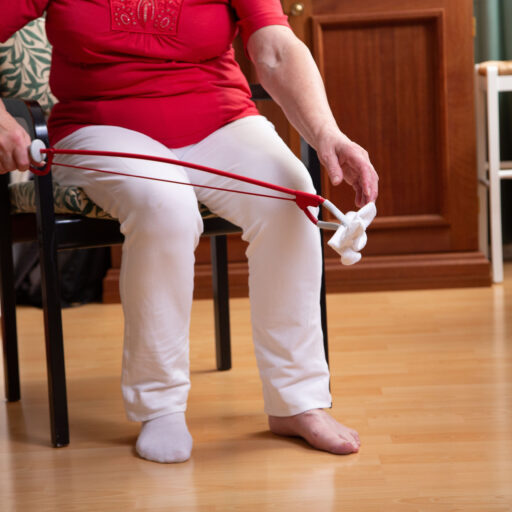 Woman using assistive devices to grab sock