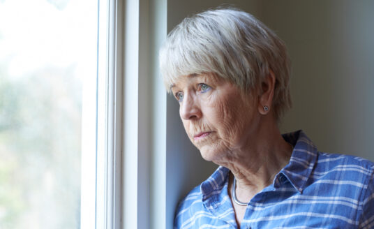 Worried Woman Looking Out Window | Agoraphobia in Seniors