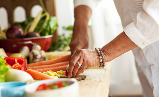 Senior woman preparing vegetables and healthy food
