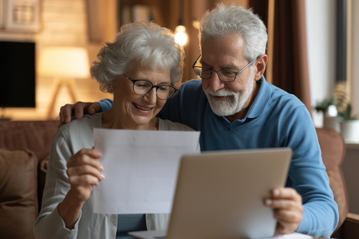 Happy older man and woman looking at their life insurance policies.