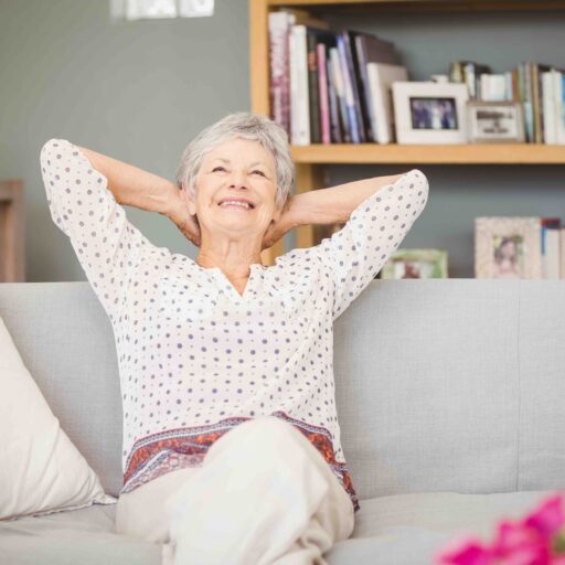 An elderly woman relaxing comfortably at home, suggesting the importance of choosing an apartment floor plan suitable for enjoyment during retirement years.