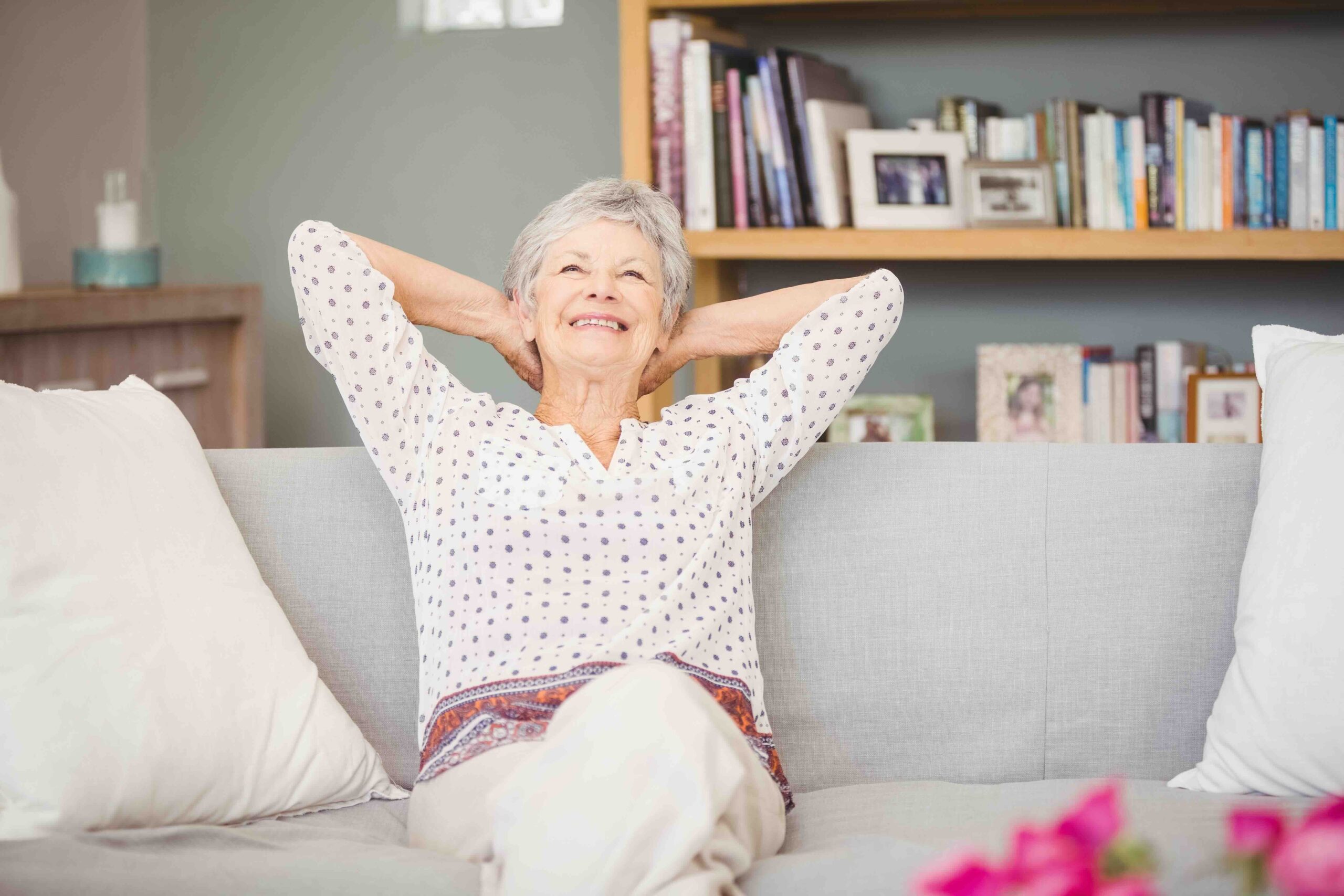An elderly woman relaxing comfortably at home, suggesting the importance of choosing an apartment floor plan suitable for enjoyment during retirement years.