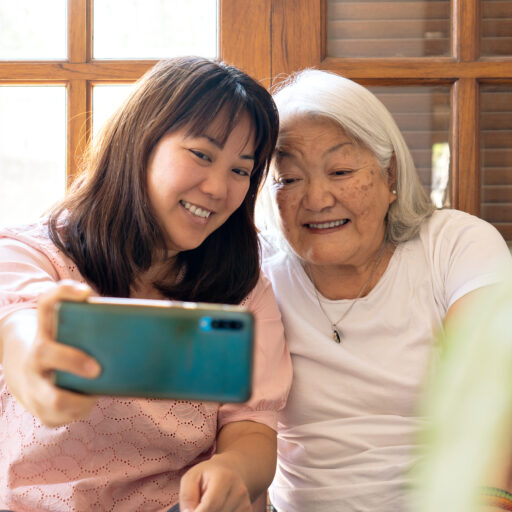 Granddaughter and senior grandmother staying connected using a smartphone