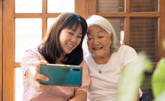 Granddaughter and senior grandmother staying connected using a smartphone