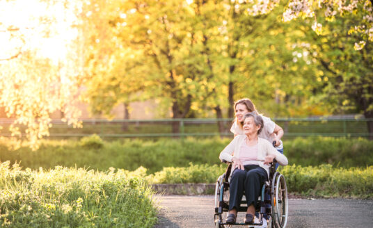 Young woman walking with senior woman in park | Explore St. Louis accessible parks near you