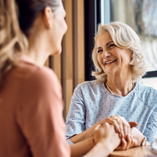 Happy senior woman enjoys in conversation with her adult daughter in cafe.