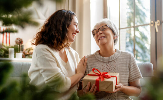 Senior woman receiving holiday gifts and gadgets for seniors