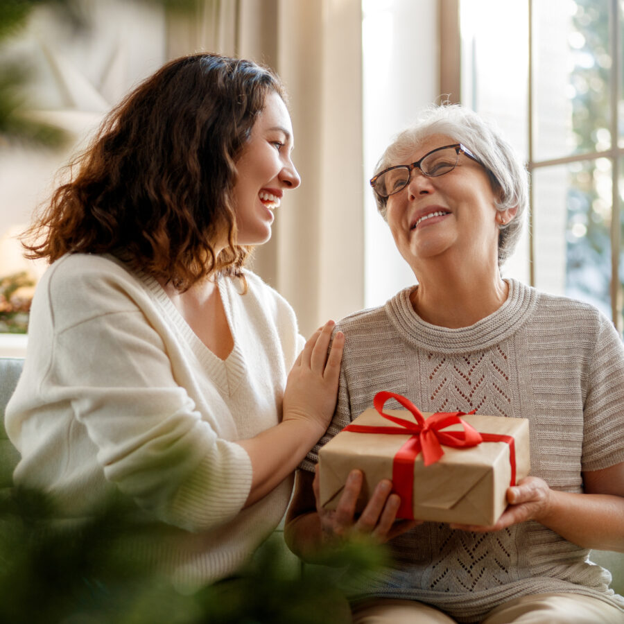 Senior woman receiving holiday gifts and gadgets for seniors