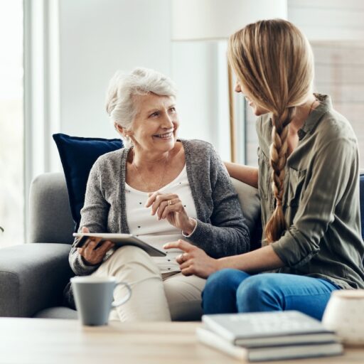 Tablet, living room and woman with senior mother in home for help with online blog