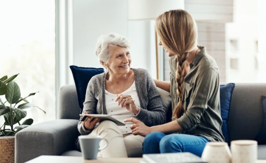 Tablet, living room and woman with senior mother in home for help with online blog