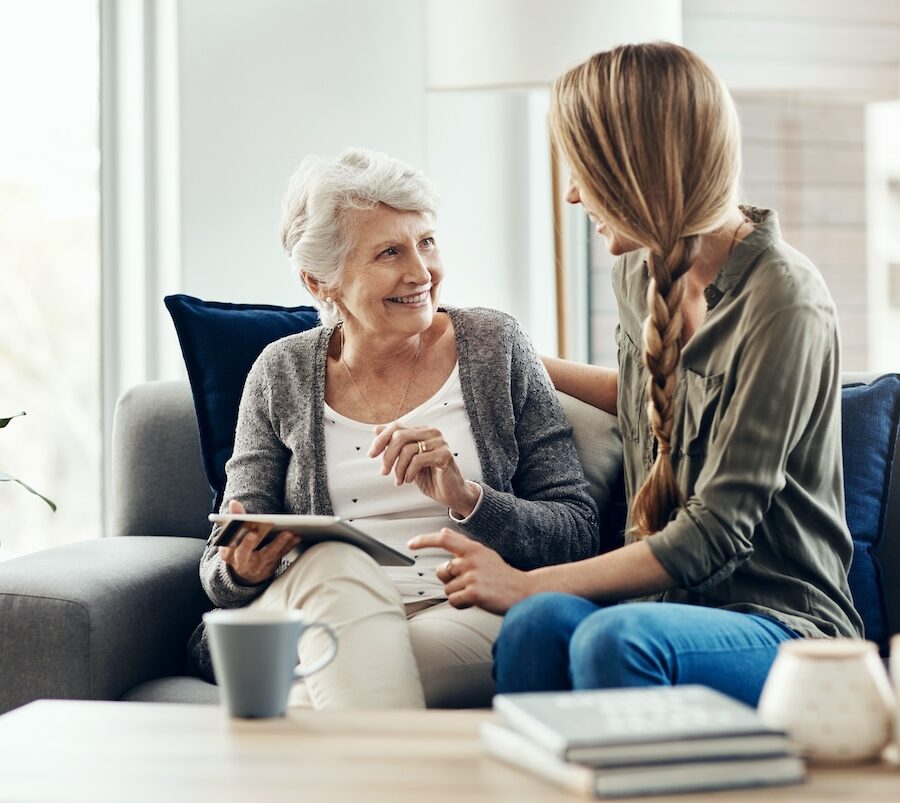 Tablet, living room and woman with senior mother in home for help with online blog