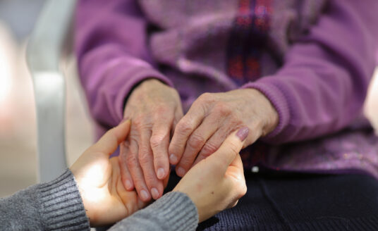 Woman comforting someone on hospice