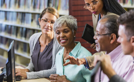 A group of adults and seniors taking part in library programs