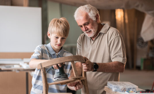 Grandfather and grandson woodworking, a vintage craft skill passed down through generations