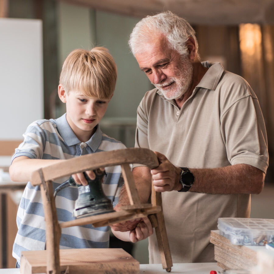 Grandfather and grandson woodworking, a vintage craft skill passed down through generations