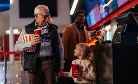 Grandfather using senior discounts to take granddaughter to the movies