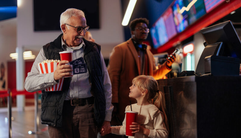 Grandfather using senior discounts to take granddaughter to the movies
