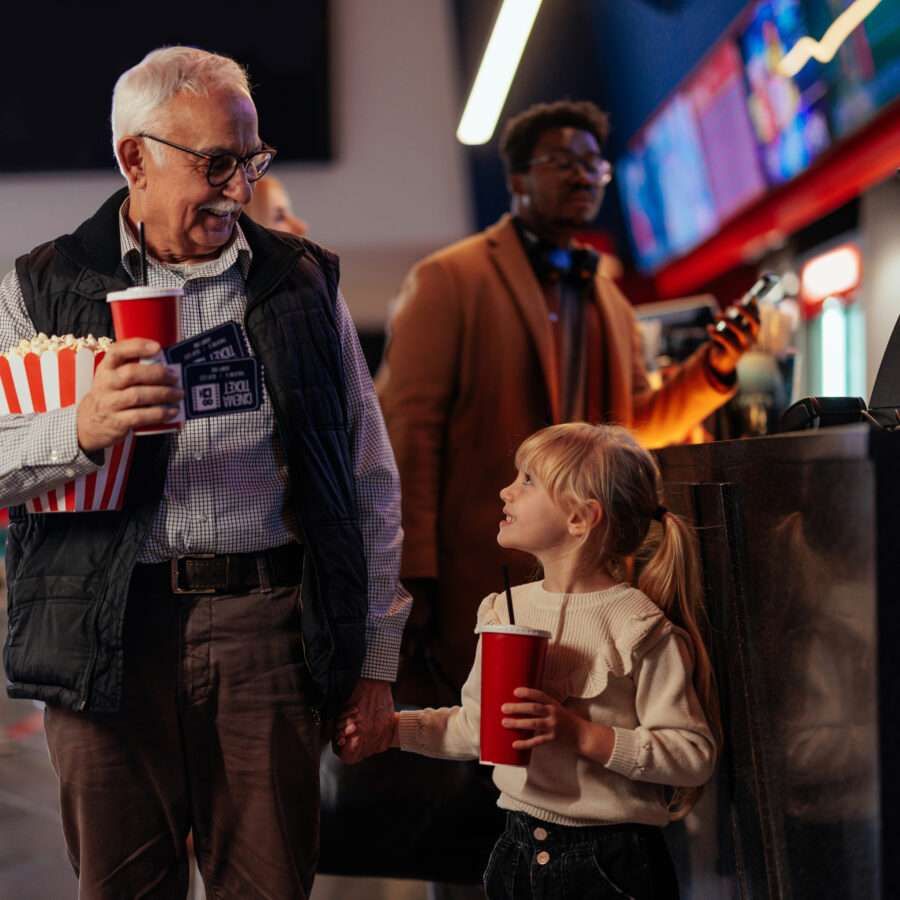 Grandfather using senior discounts to take granddaughter to the movies