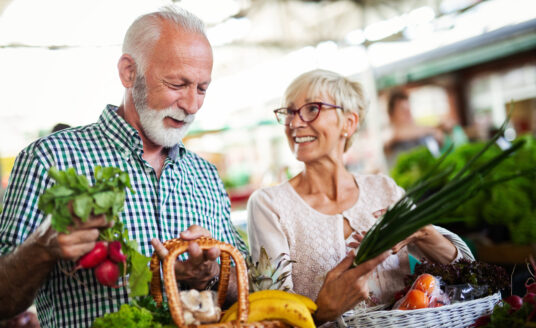 Senior couple picking out vegetables at local farmers market