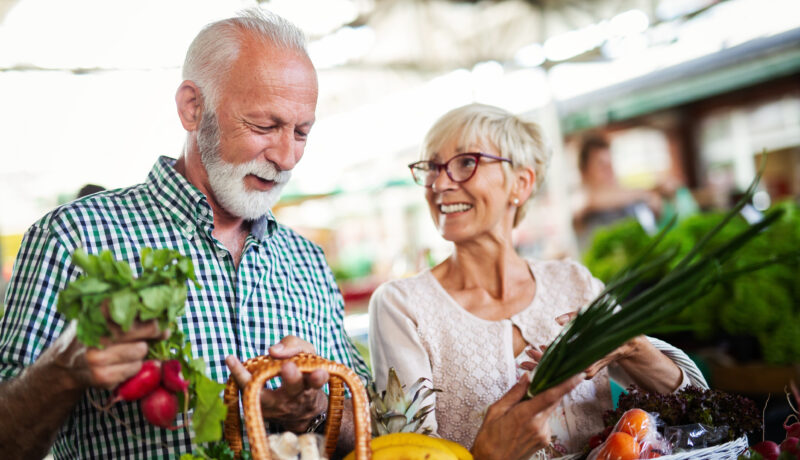 Senior couple picking out vegetables at local farmers market