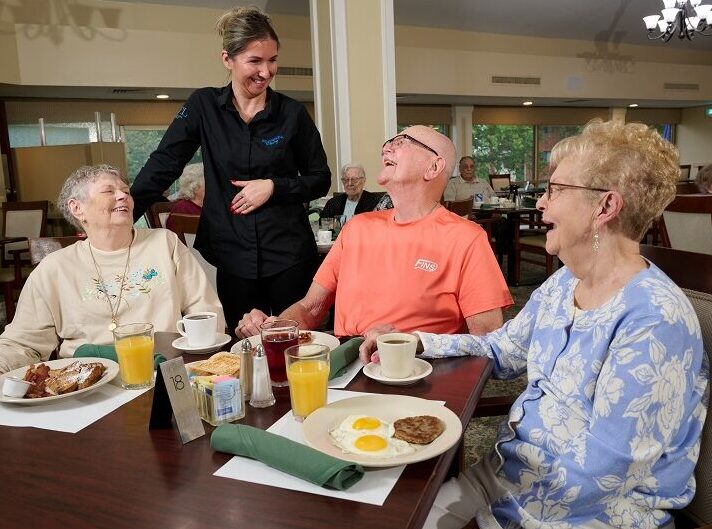 Bethesda Terraces residents socializing with dining employee during breakfast