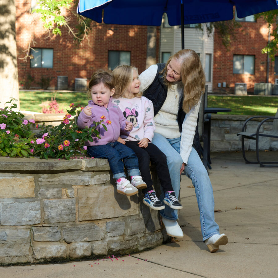 Bethesda Terrace resident sitting outside with grandchildren