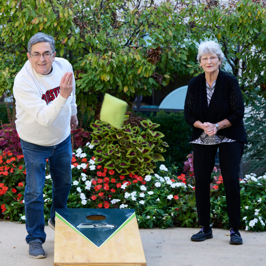 Bethesda Terrace residents playing cornhole outdoors