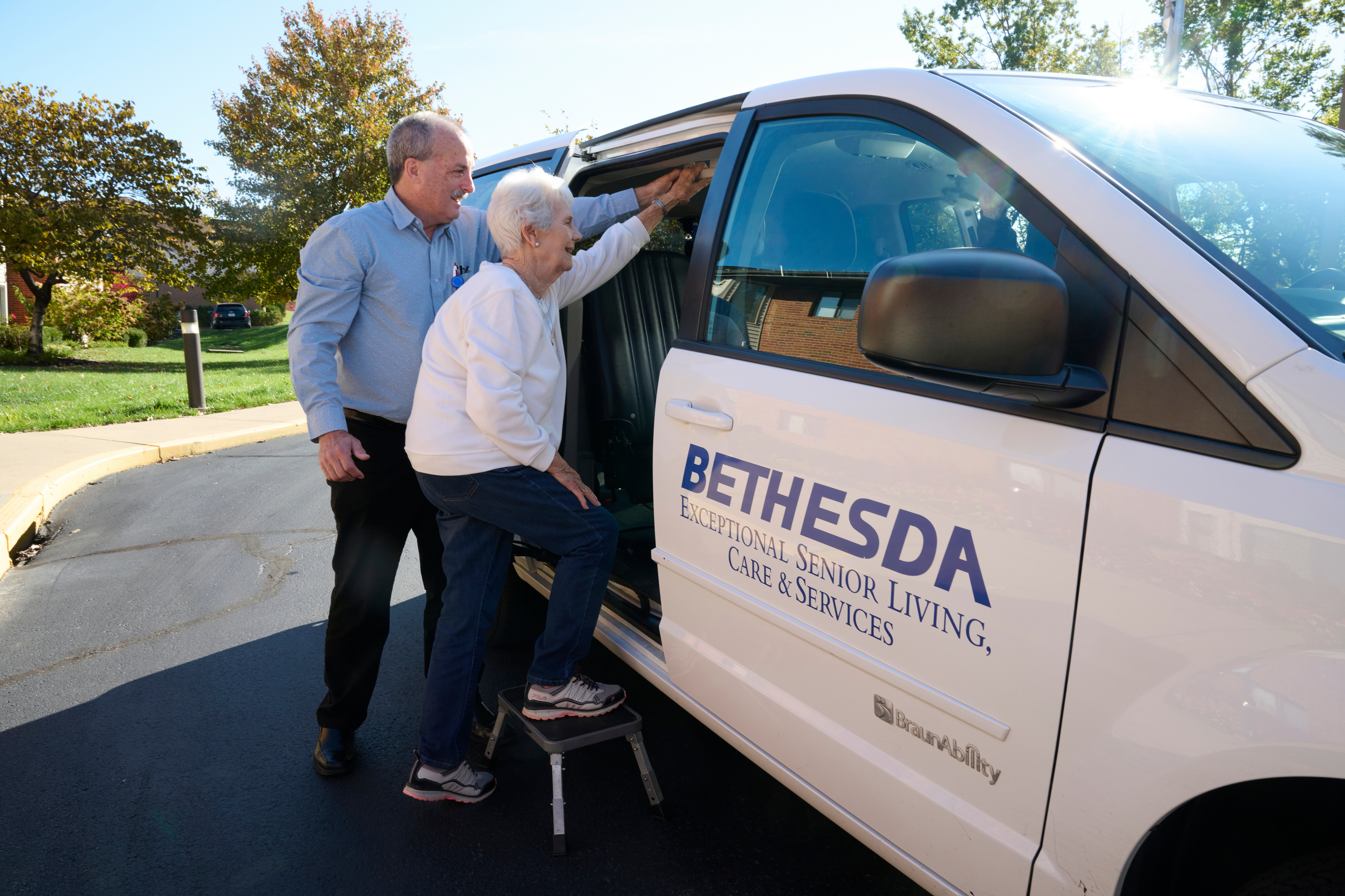Bethesda Terrace resident getting in transportation van with Bethesda staff member