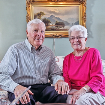 George and Barbara smiling on a couch