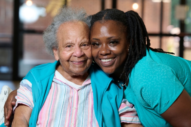Senior with a caregiver smiling together