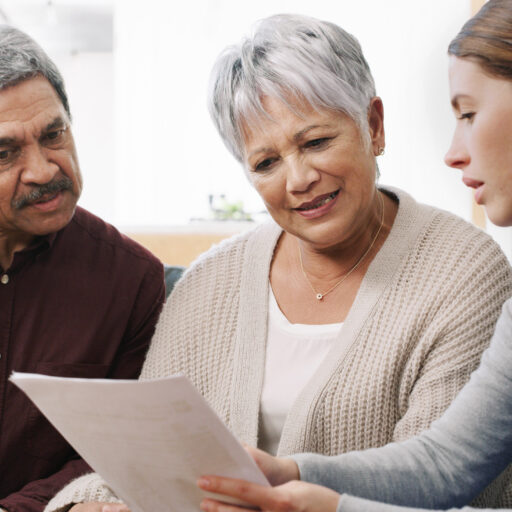 Care management professional teaching senior couple about personalized care plans
