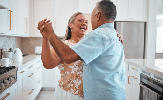 Senior couple smiling and dancing, overcoming myths about aging